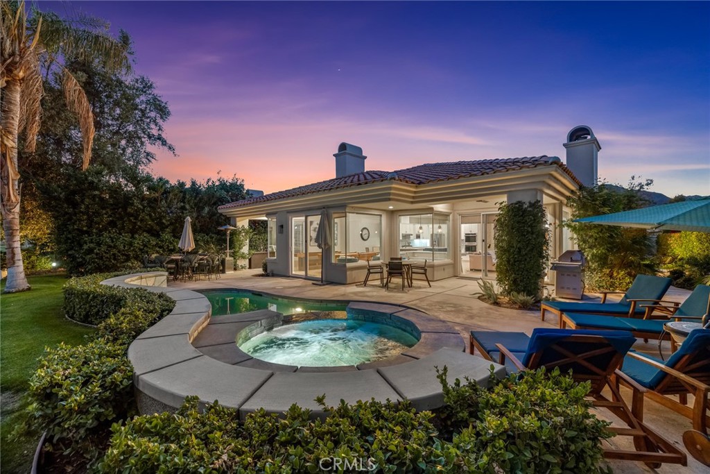 a view of a house with backyard water fountain and sitting area