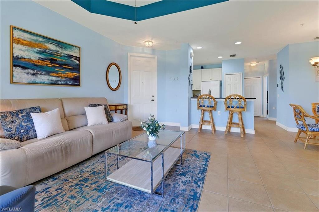 a living room with furniture and kitchen view