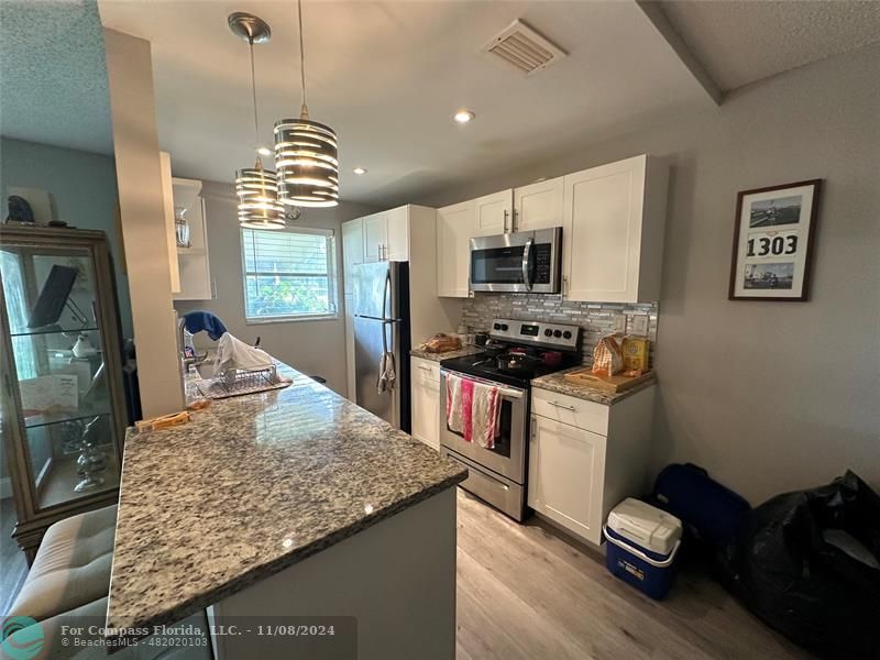 a kitchen with sink refrigerator and microwave