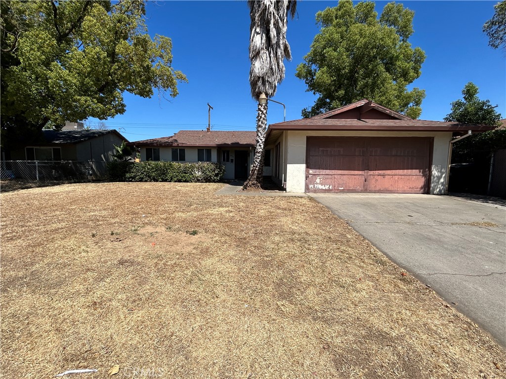 a view of a yard in front of a house with a large tree