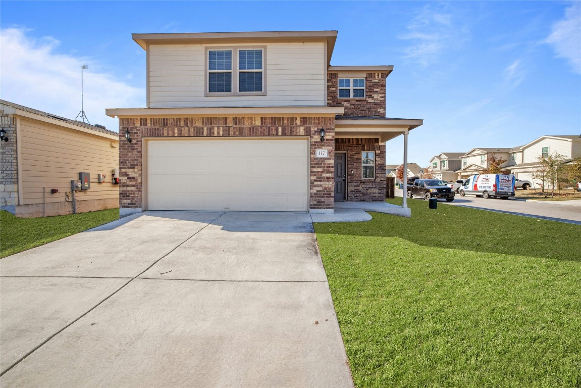 a front view of a house with a yard and garage