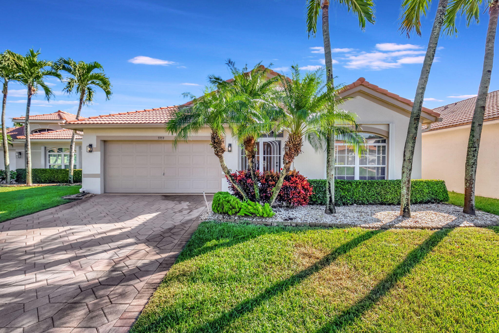 a front view of a house with a yard and potted plants