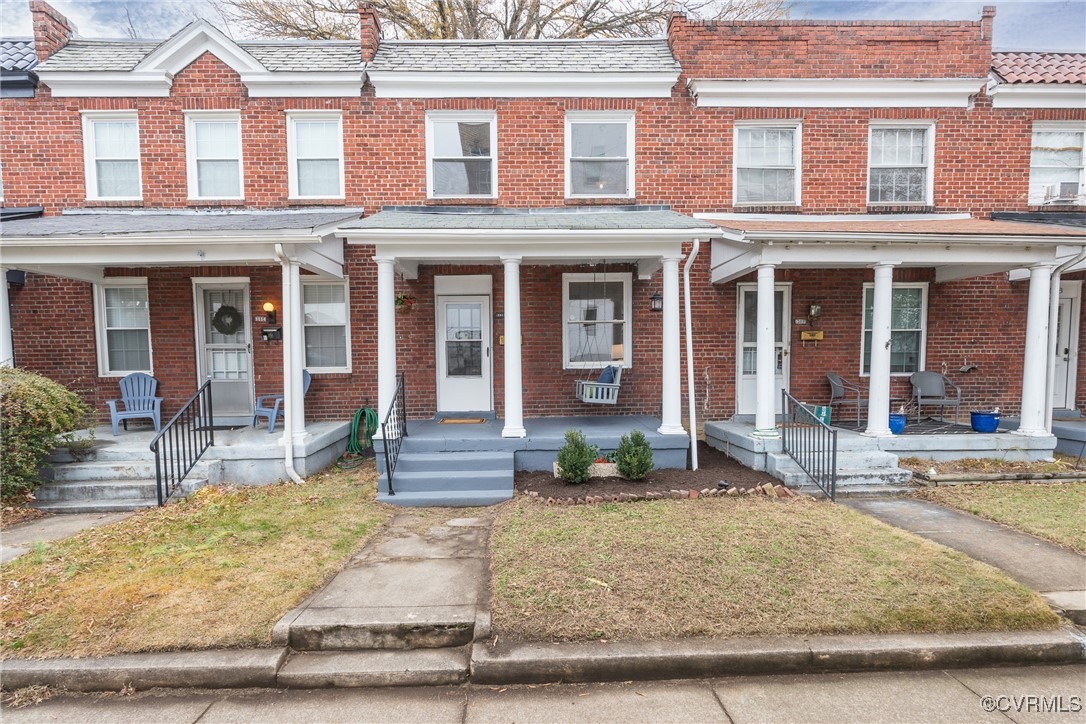 front view of a brick house with a yard