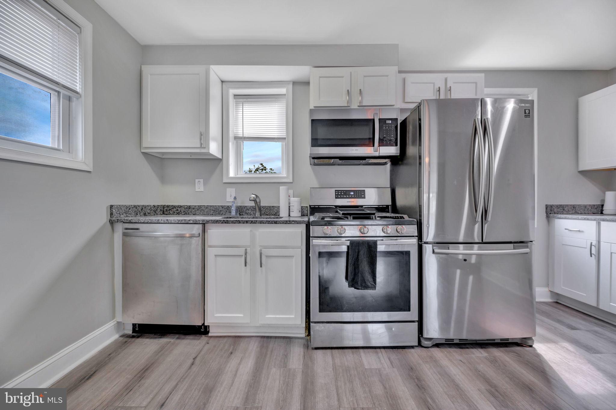 a kitchen with cabinets stainless steel appliances a sink and a window