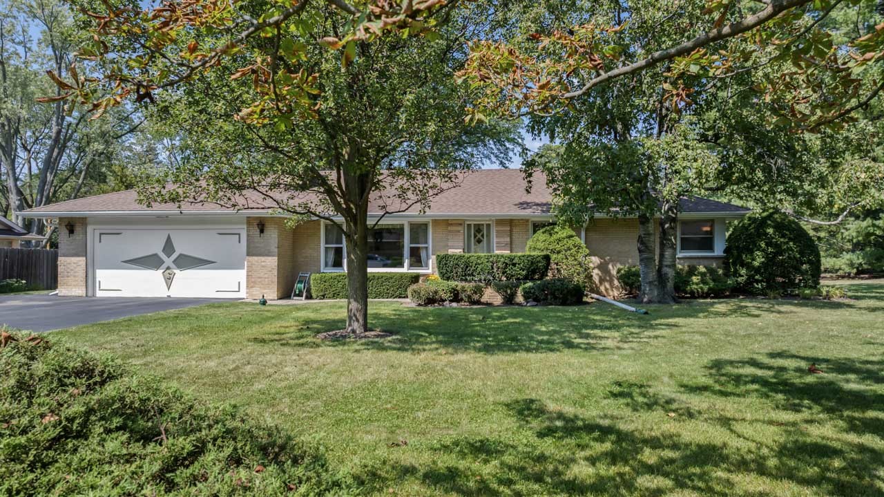 a front view of a house with a yard and trees