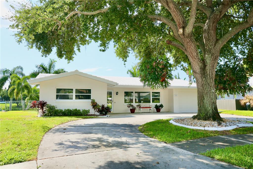 a front view of a house with a yard and trees