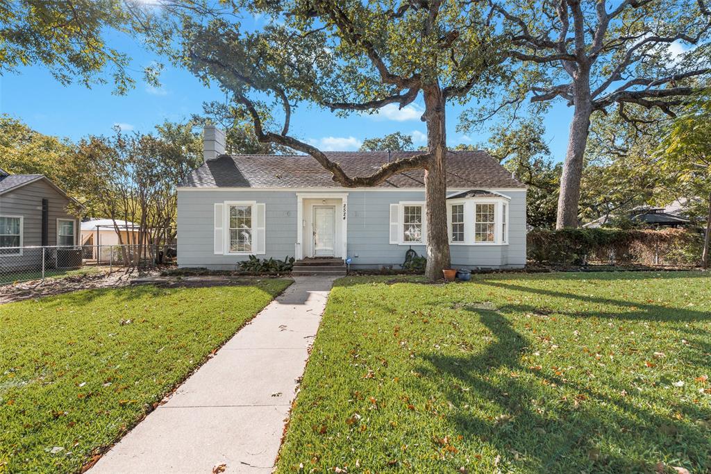 a front view of a house with a garden and trees