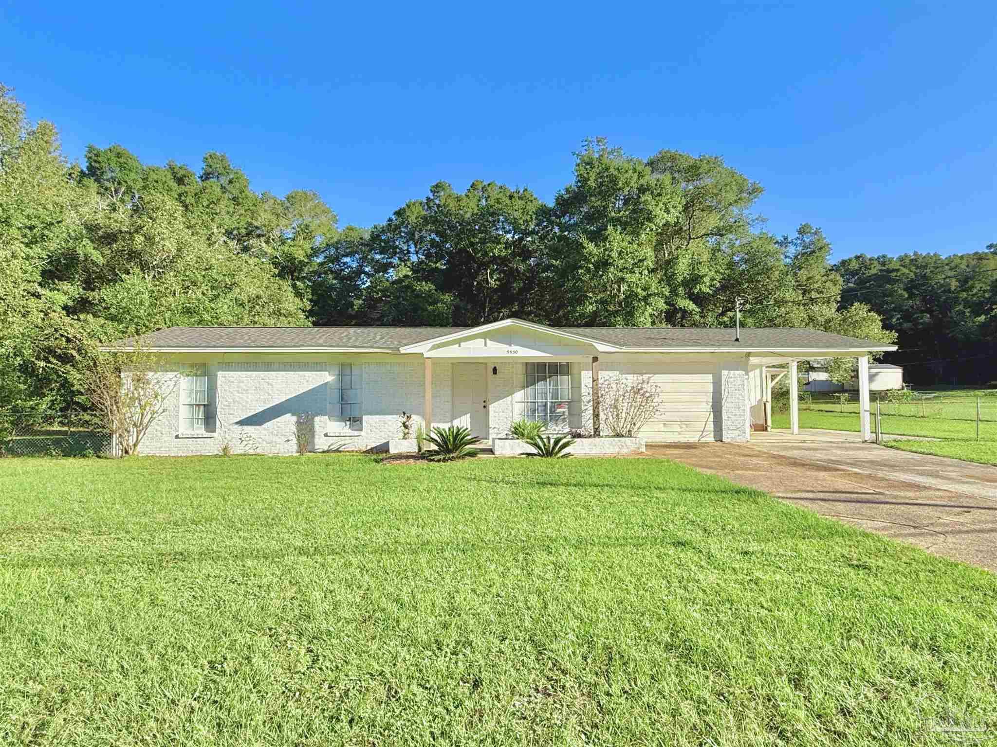 a view of a house with a yard and sitting area