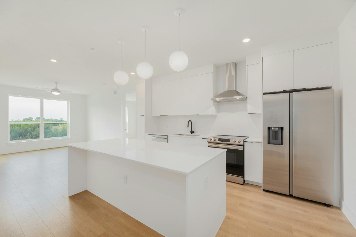 a kitchen with stainless steel appliances a refrigerator sink and stove