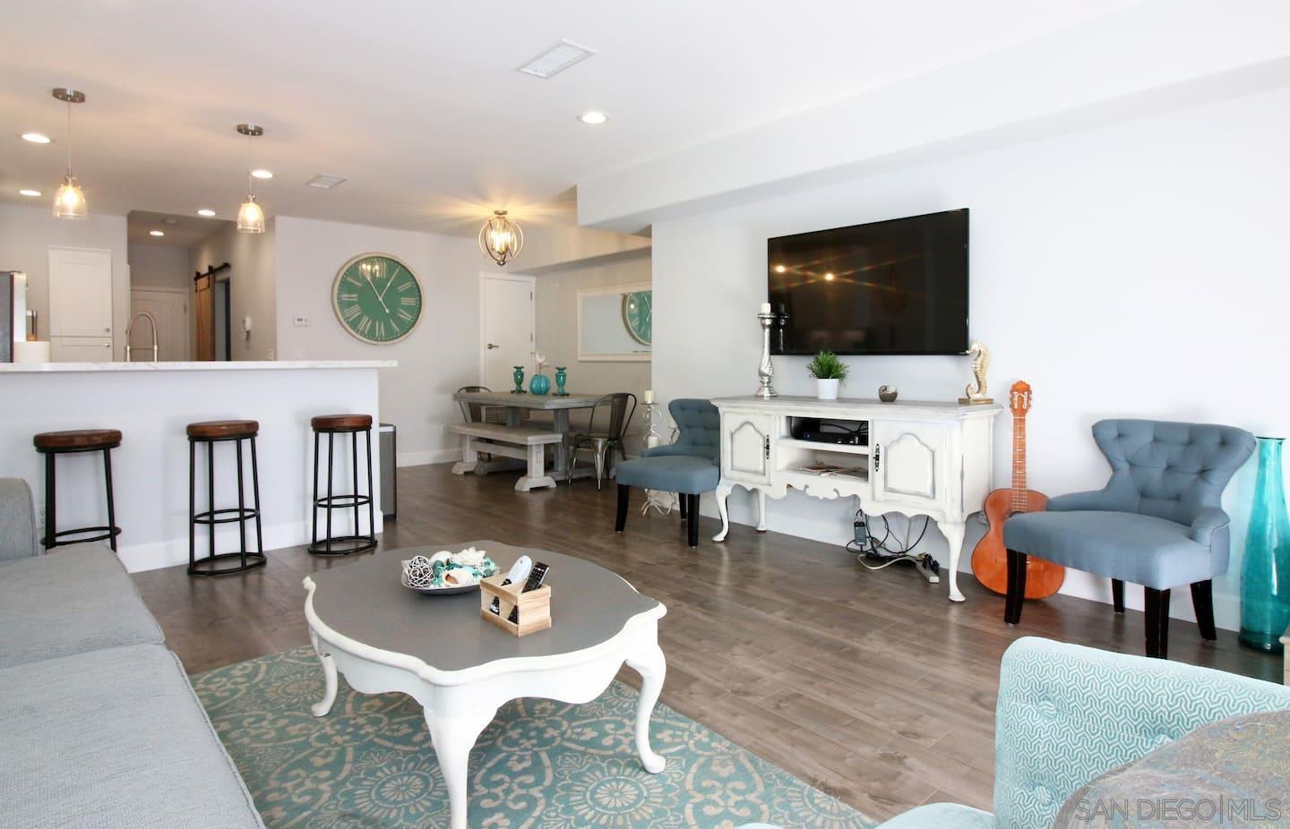 a living room with furniture kitchen view and a flat screen tv