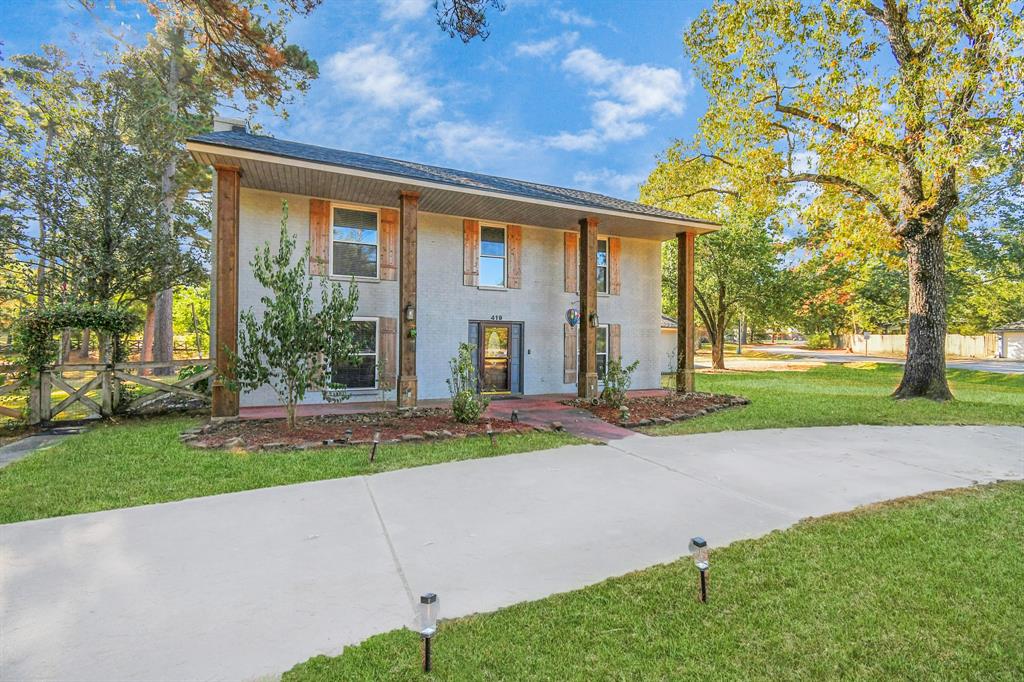 a view of a house with a yard and tree s