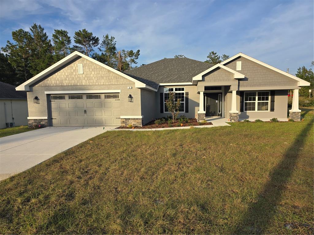 a front view of house with yard and trees in the background