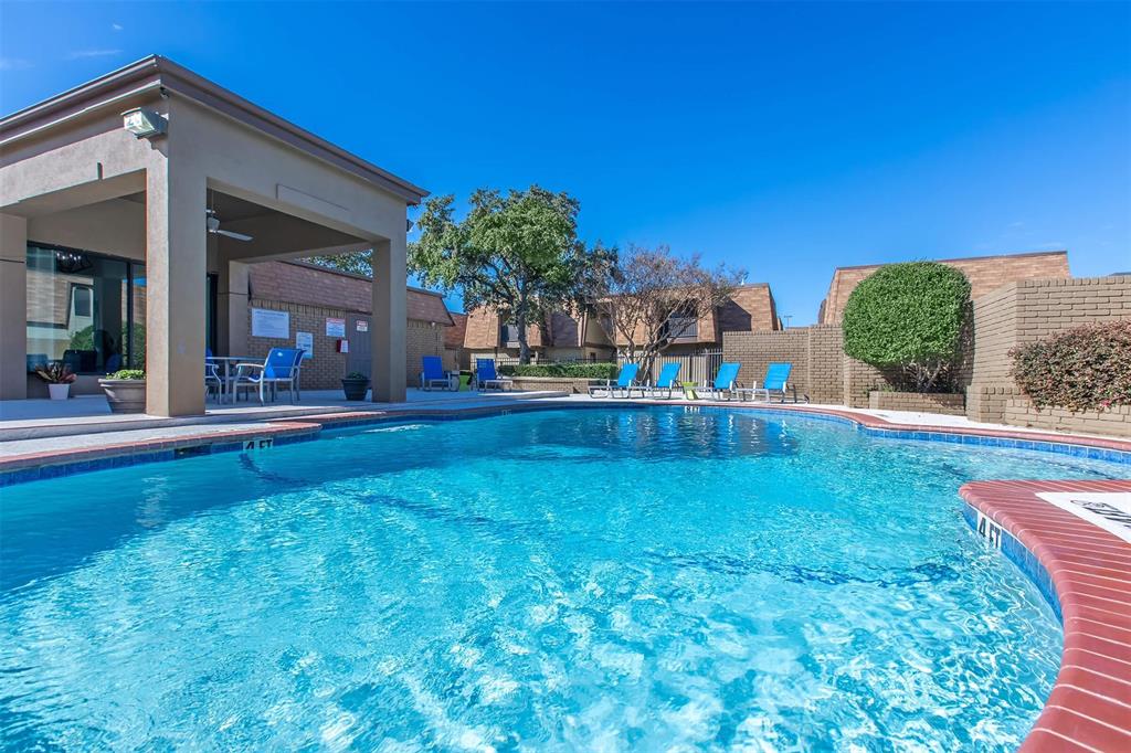 a view of swimming pool with lawn chairs and plants