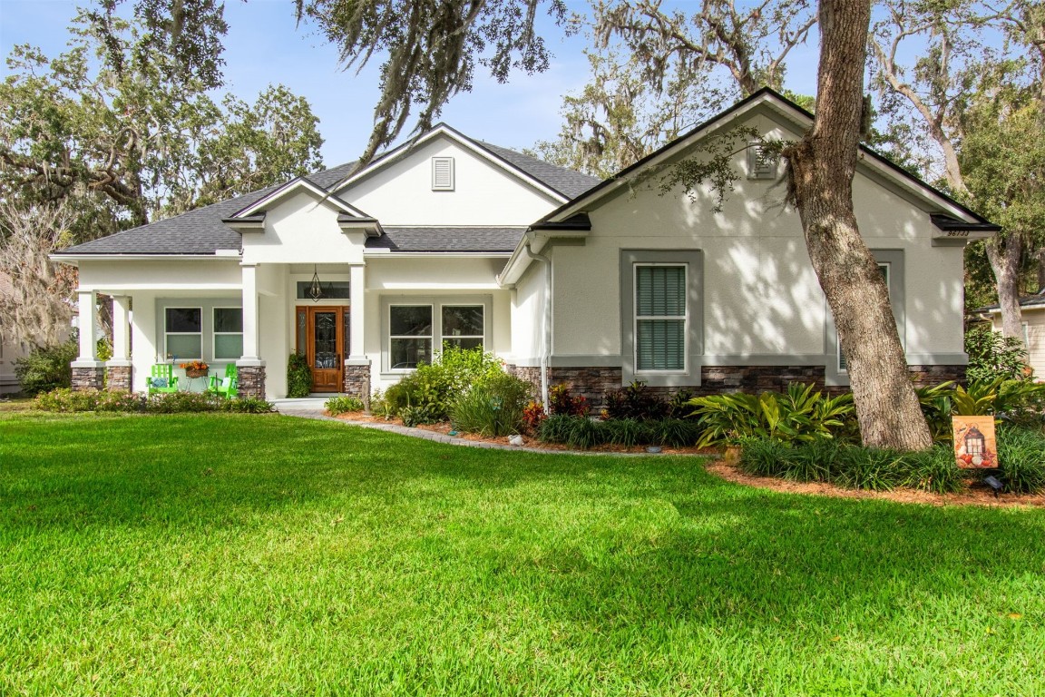 a front view of a house with a yard and potted plants