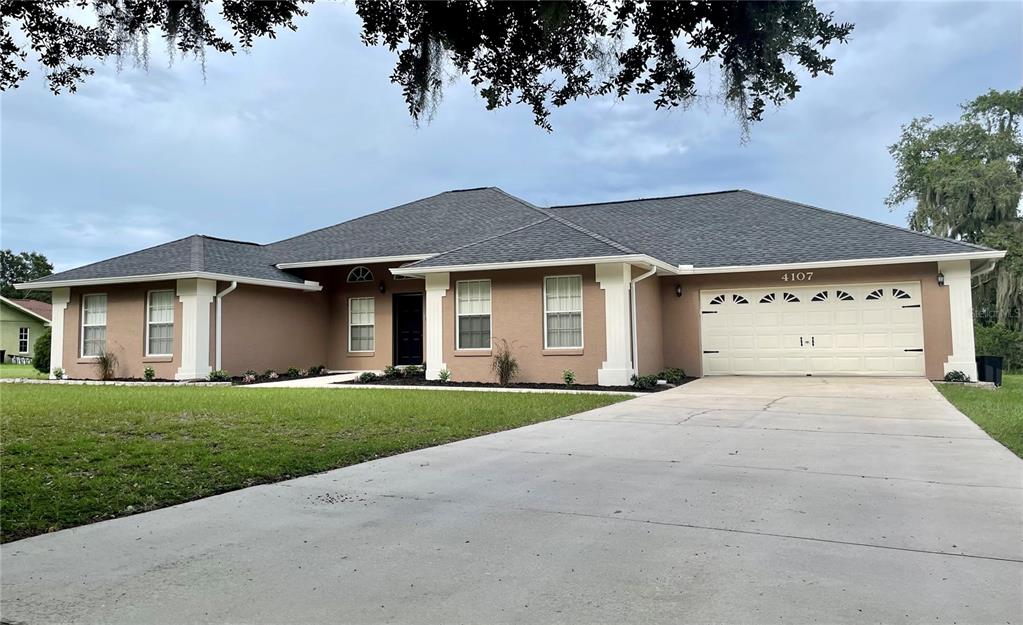 a front view of a house with a garden and yard