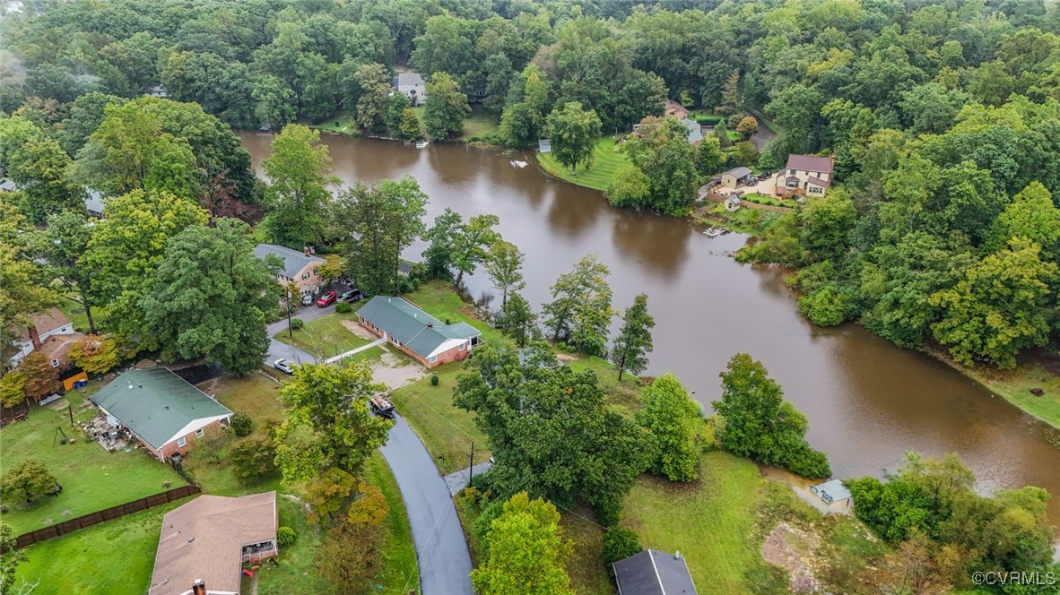 an aerial view of a house with a yard and lake view