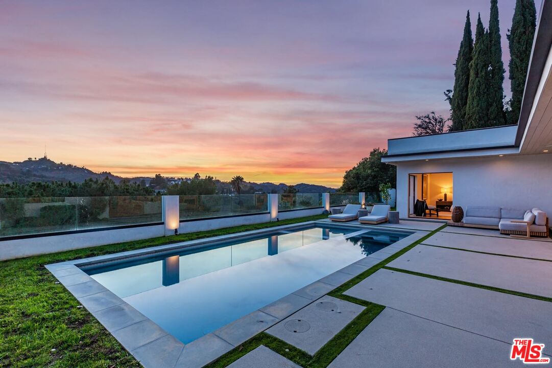 a view of swimming pool with outdoor seating and a garden