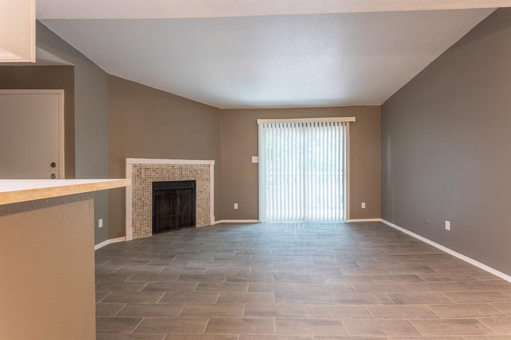 a view of an empty room with a fireplace and a window