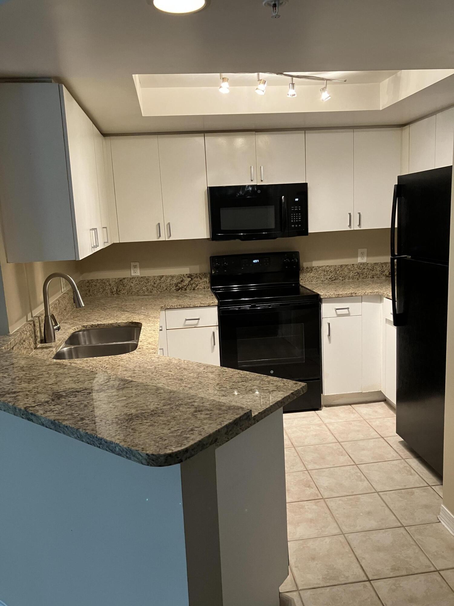 a kitchen with granite countertop a sink and a stove top oven