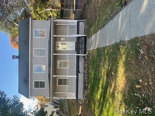 View of front of property featuring covered porch and a front lawn