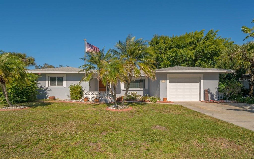 a front view of house with yard and trees in the background