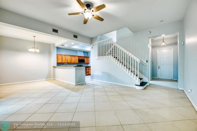 a view of an empty room and kitchen view