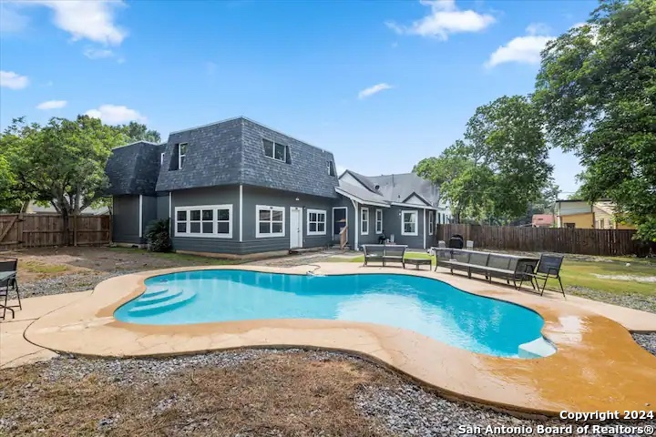 a view of a house with swimming pool and sitting area