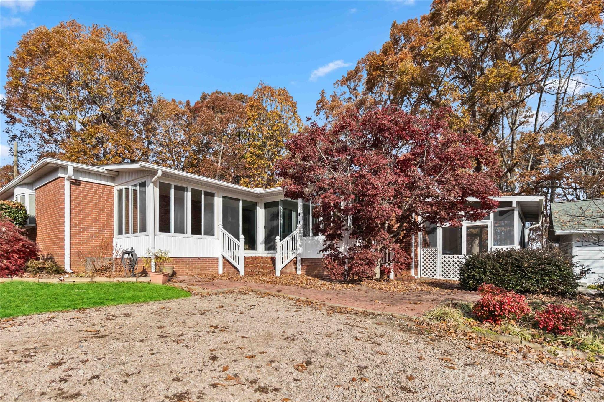 a front view of house with yard and trees in the background