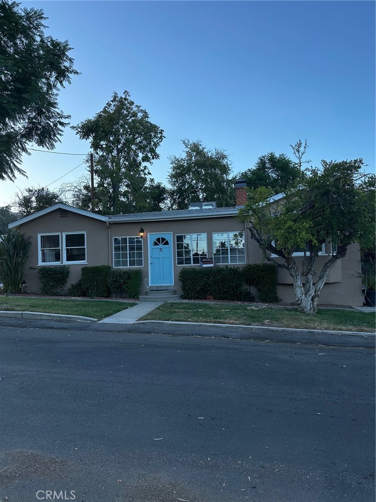 a front view of a house with a yard and potted plants