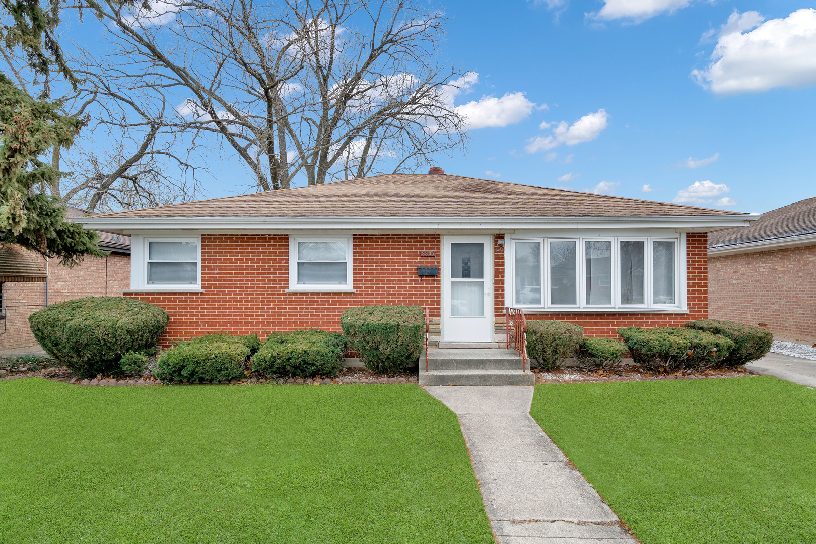 a front view of a house with a garden and yard