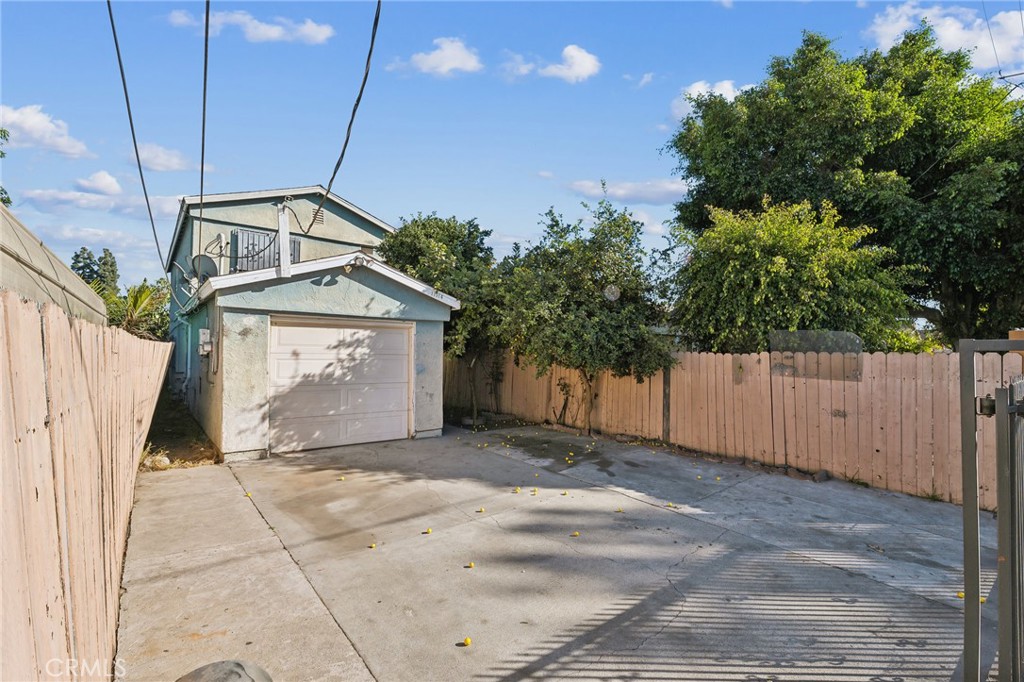 a view of a house with a small yard and wooden fence