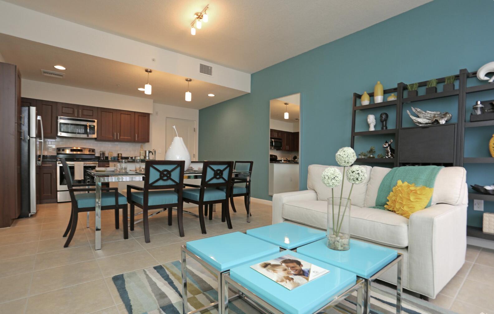 a living room with furniture a table and kitchen view