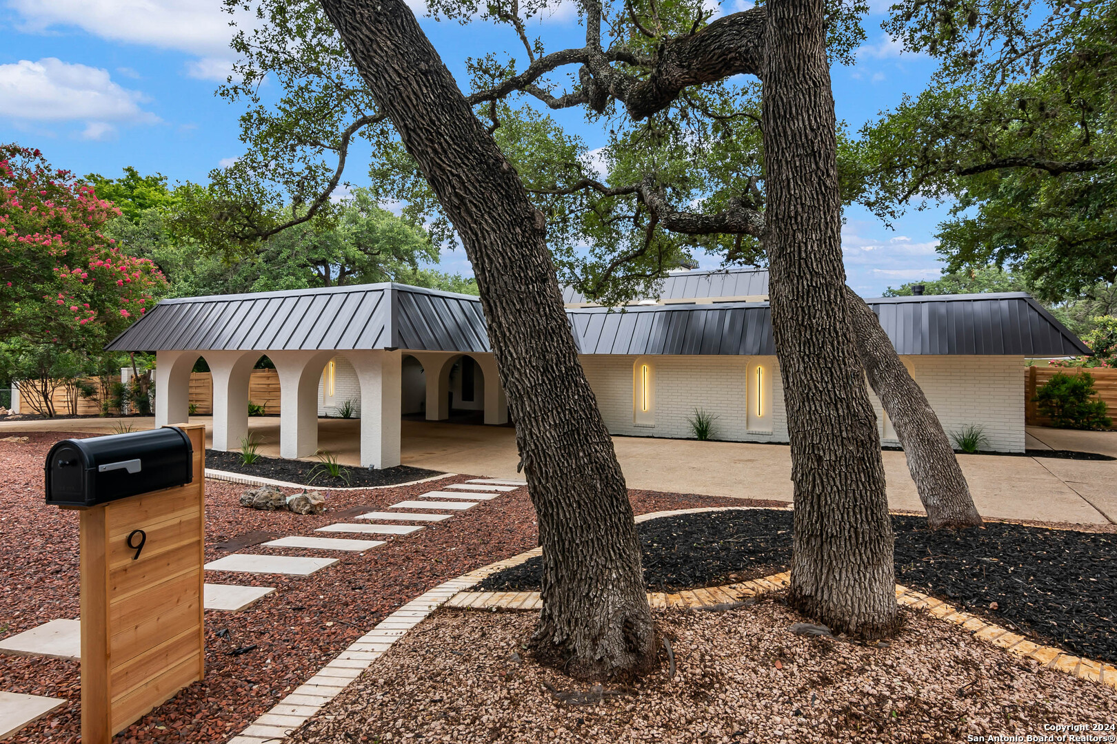 a front view of a house with a tree