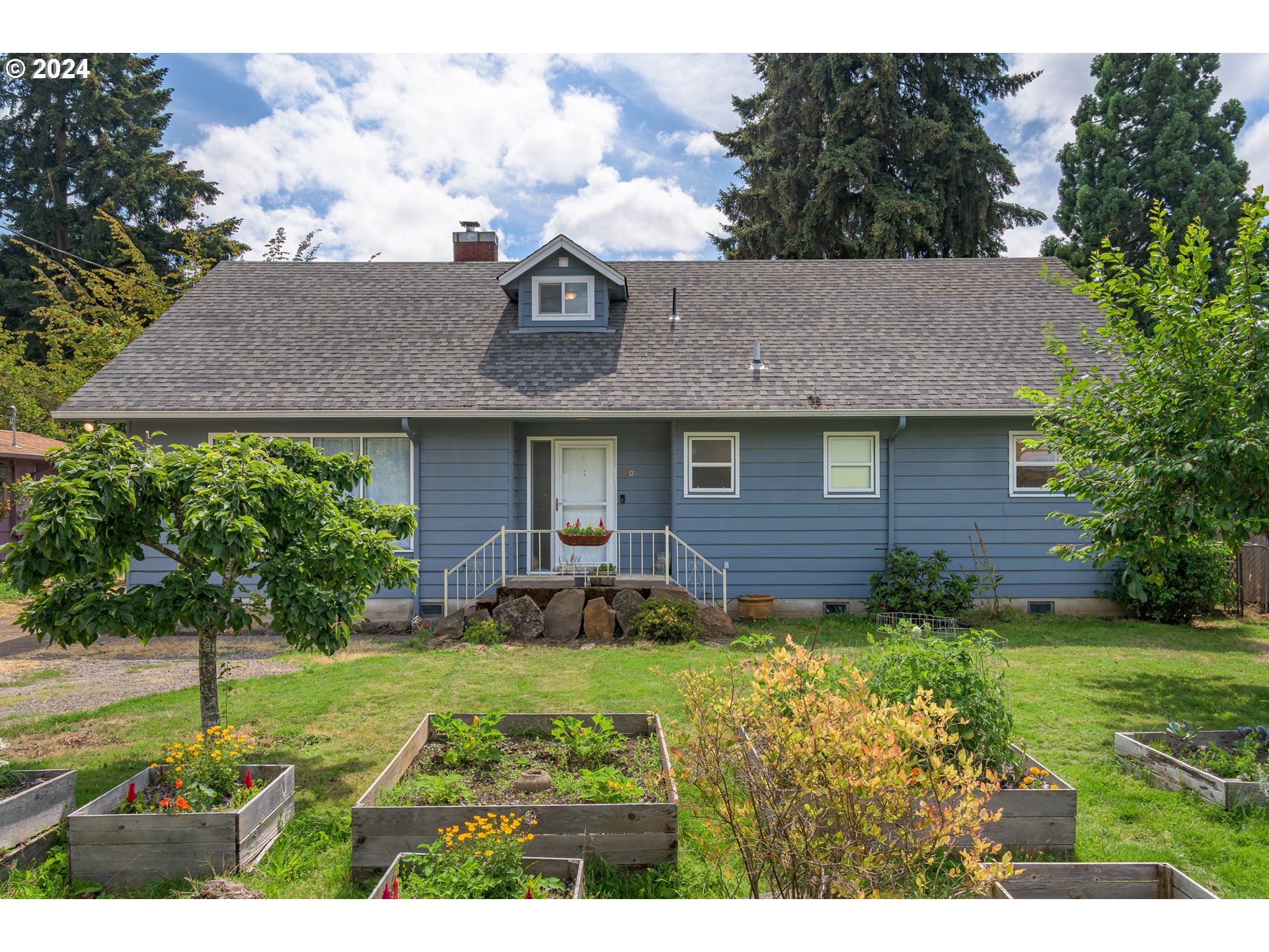 a view of a house with a yard and potted plants