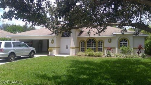 View of front of property featuring a garage and a front lawn