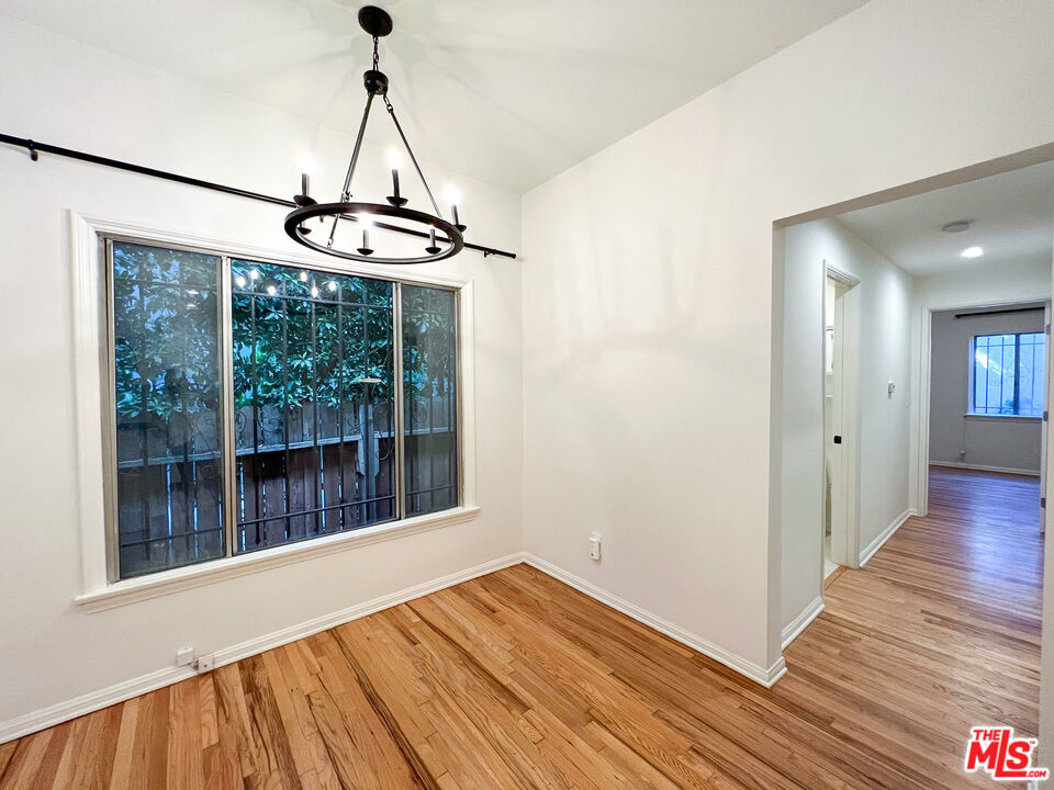 a view of empty room with wooden floor and windows