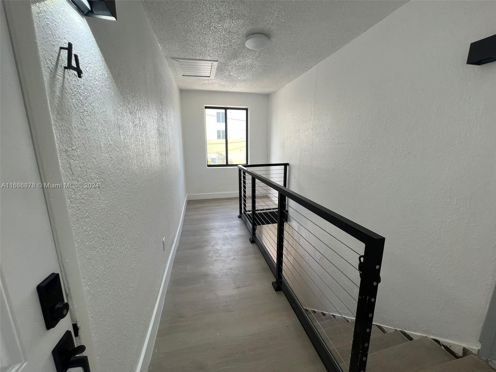 a view of a hallway with windows and stairs