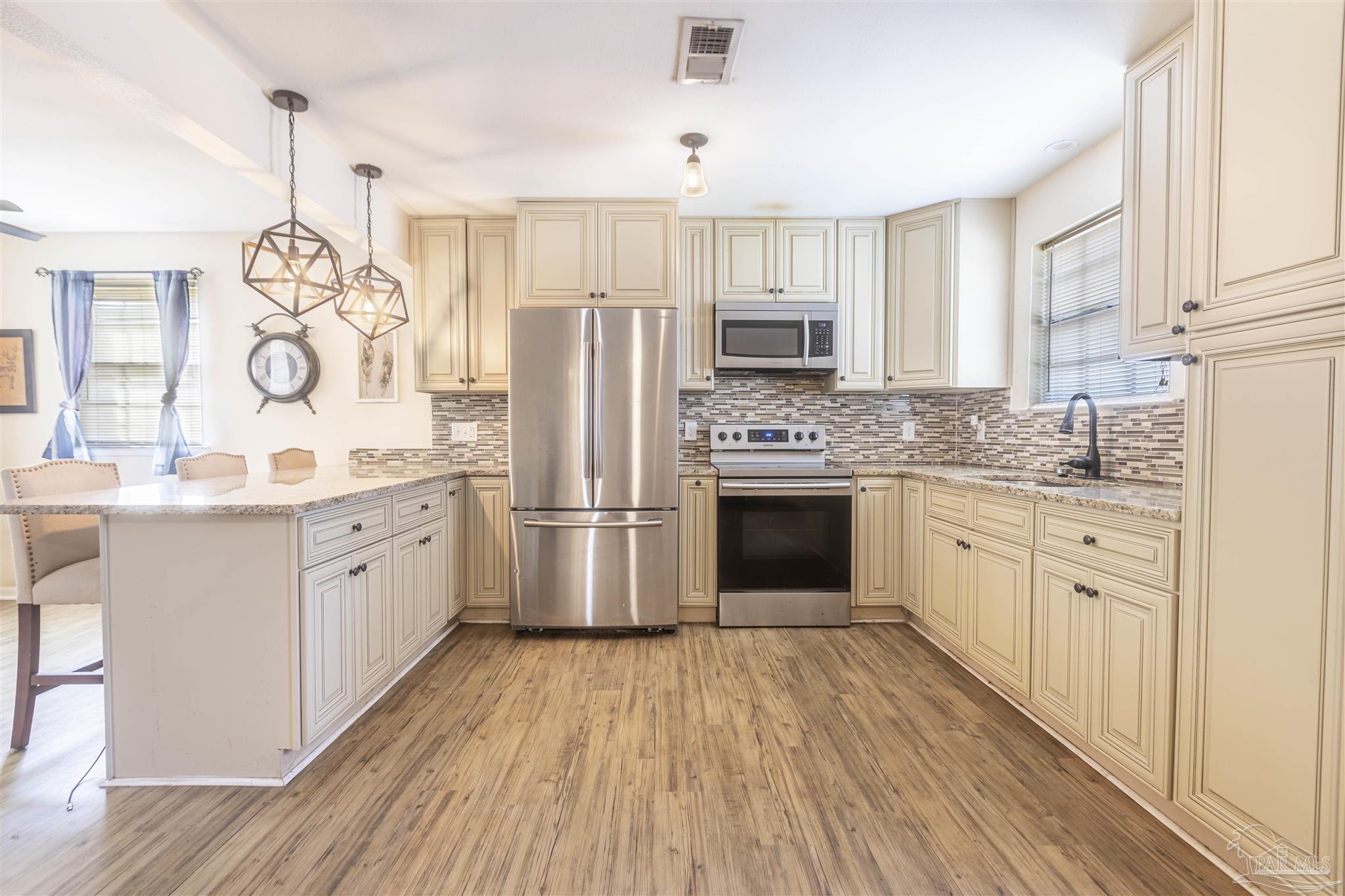 a kitchen with white cabinets stainless steel appliances and sink