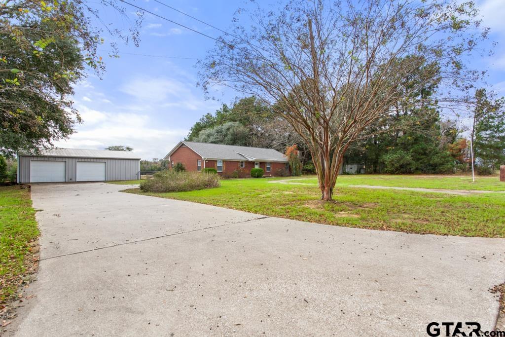 a view of a house with a big yard and large trees