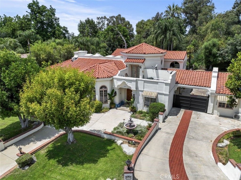 an aerial view of a house with swimming pool and garden