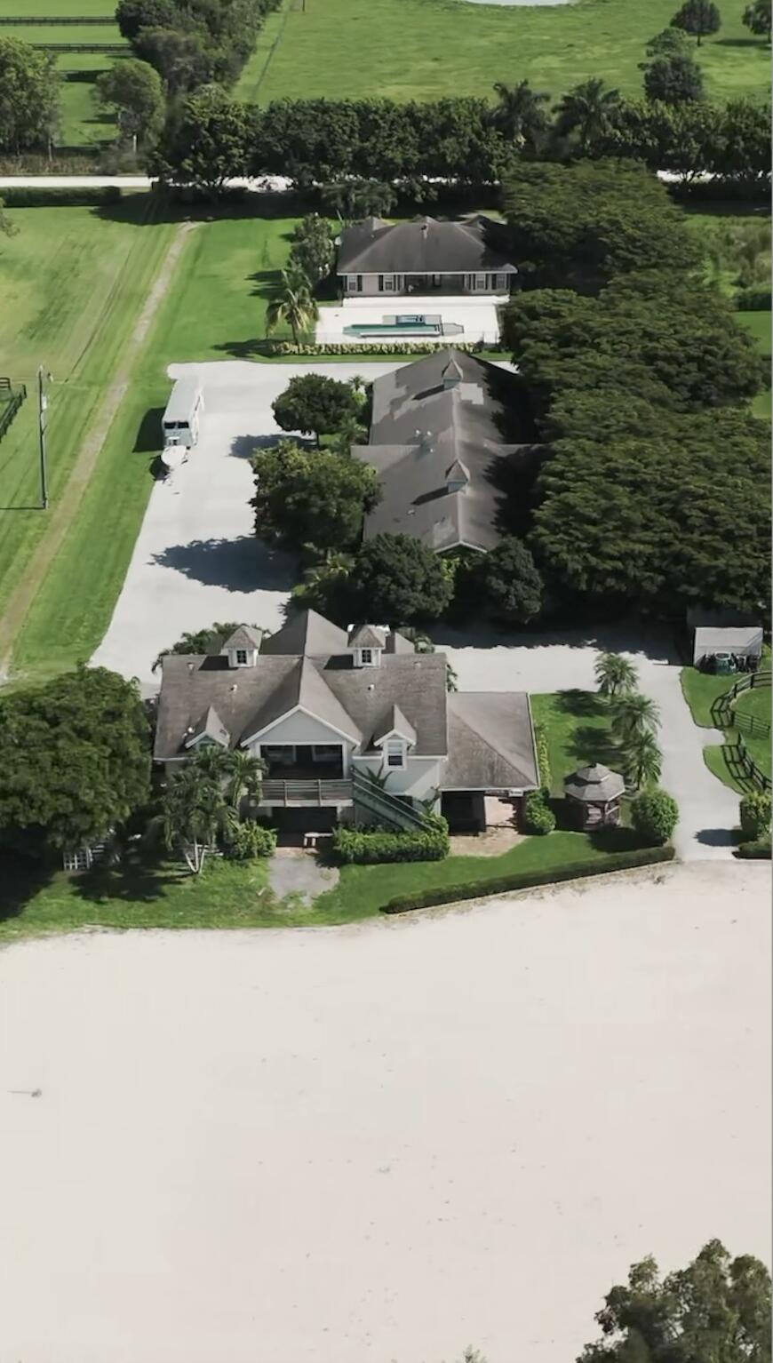 an aerial view of a house with a yard and lake view