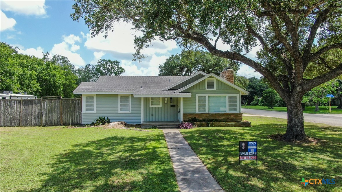 a front view of a house with yard and green space