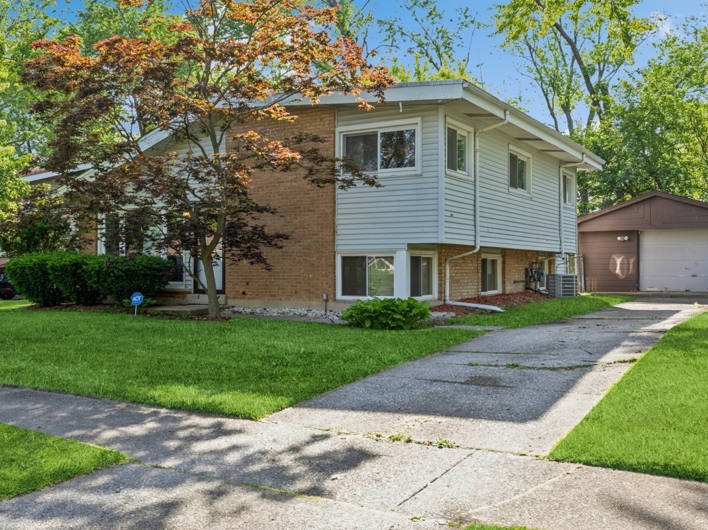 a front view of a house with a yard and trees