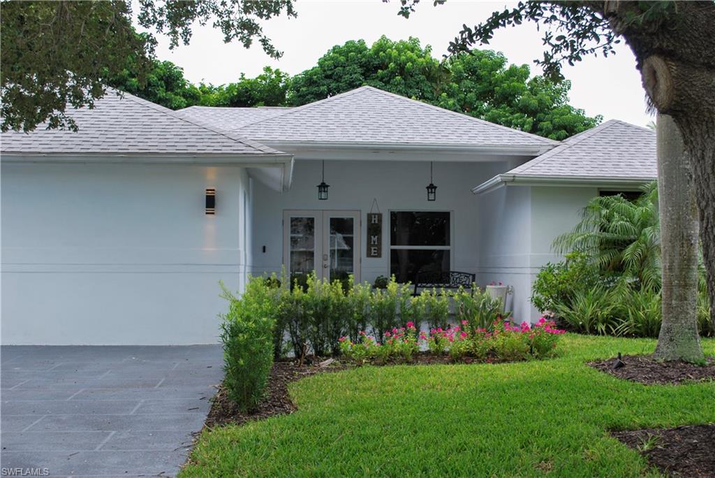 View of front of house featuring french doors and a front lawn