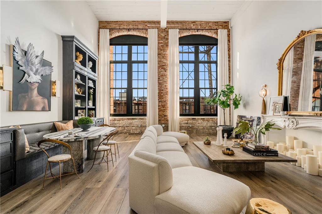 a living room with furniture fireplace and large windows