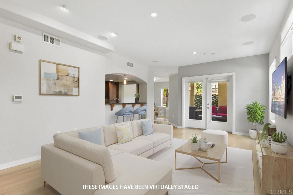 a living room with furniture a flat screen tv and a potted plant