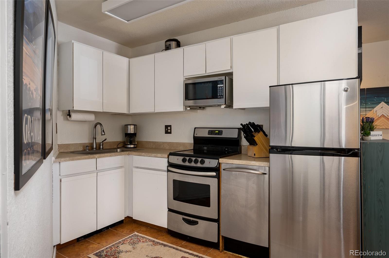 a kitchen with white cabinets and white stainless steel appliances