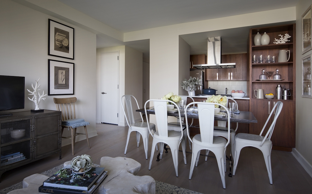 a living room with furniture kitchen view and a window