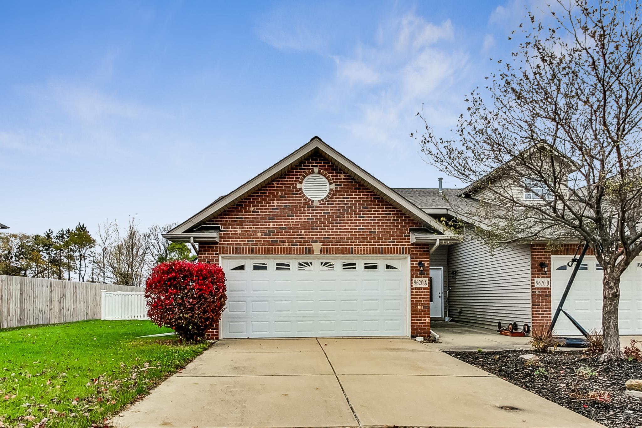 a front view of a house with a garden and garage