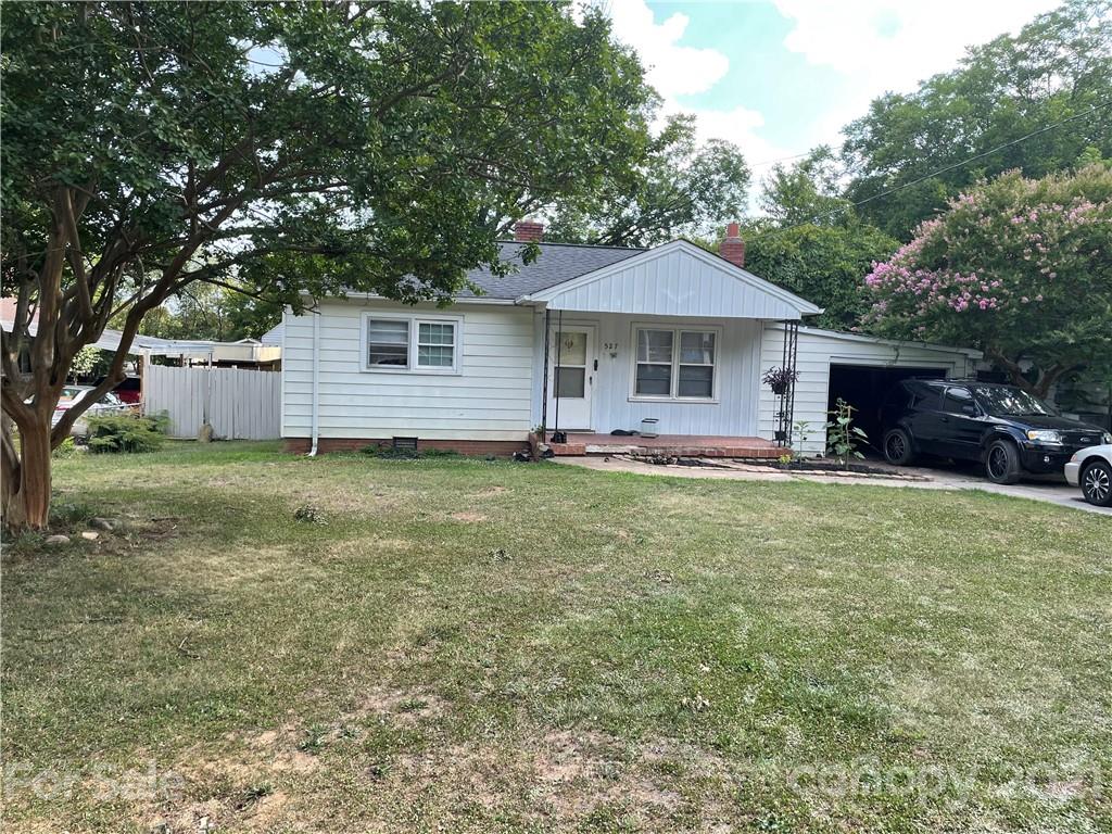 a front view of house with yard and trees in the background